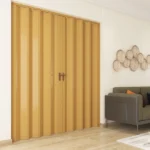 Closed honey oak PVC folding doors with bronze handles.