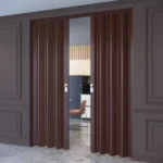 Dark wood folding doors opening to a modern kitchen.