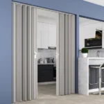 Grey accordion door partially open to modern kitchen