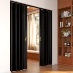 Modern black accordion door opening to sunlit room